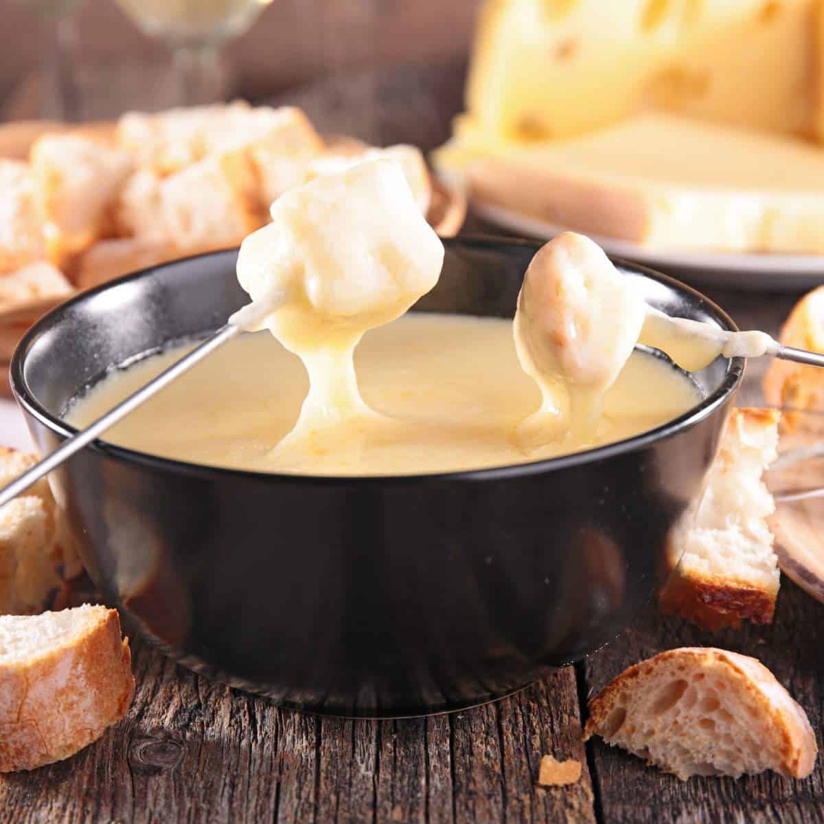 A delicious breakfast in Switzerland featuring a bowl of fondue with bread and cheese.