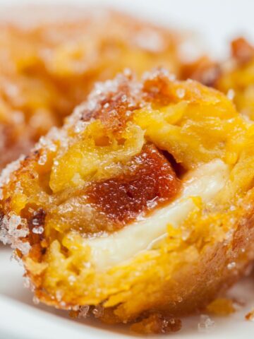 A plate of fried doughnuts, one of the best Colombian foods, sitting on a white plate.