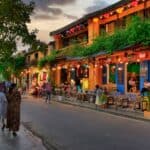 A street in Hanoi with colorful buildings and people walking on the street, dotted with charming cafes.