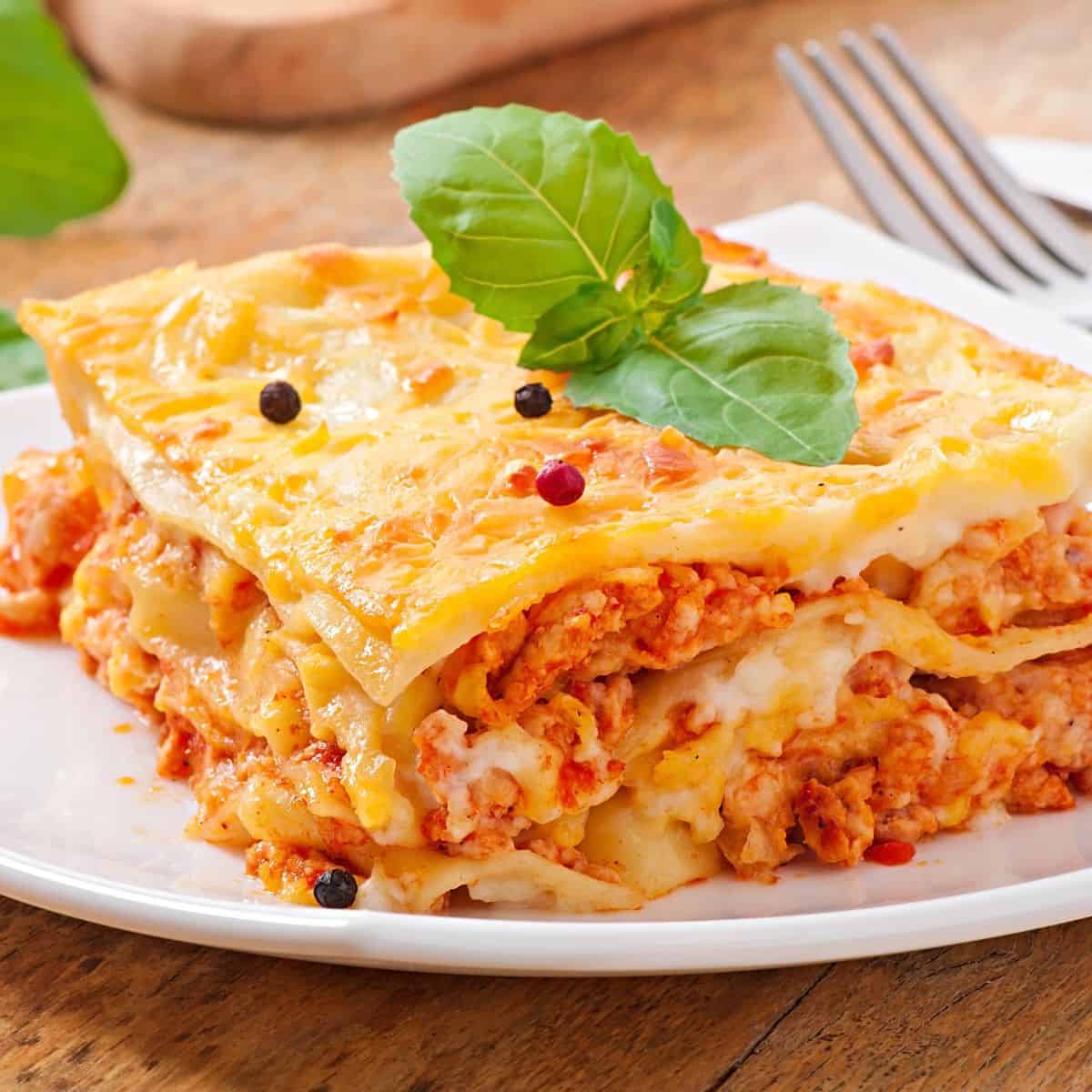 A plate of lasagna from Bologna on a wooden table.