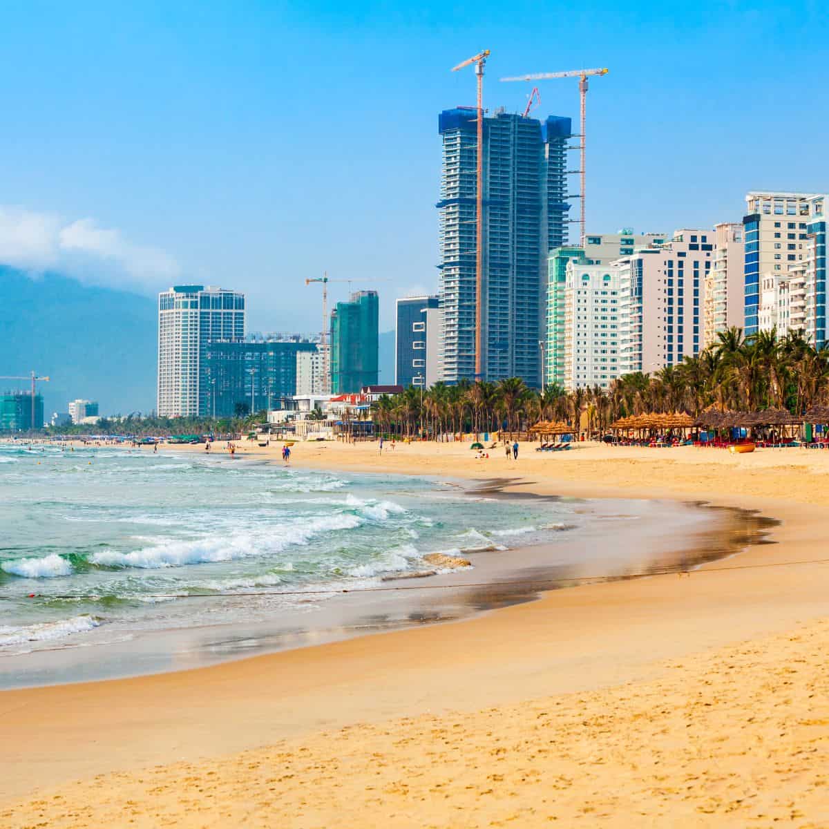A beach with tall buildings in the background, offering the best food in Danang.