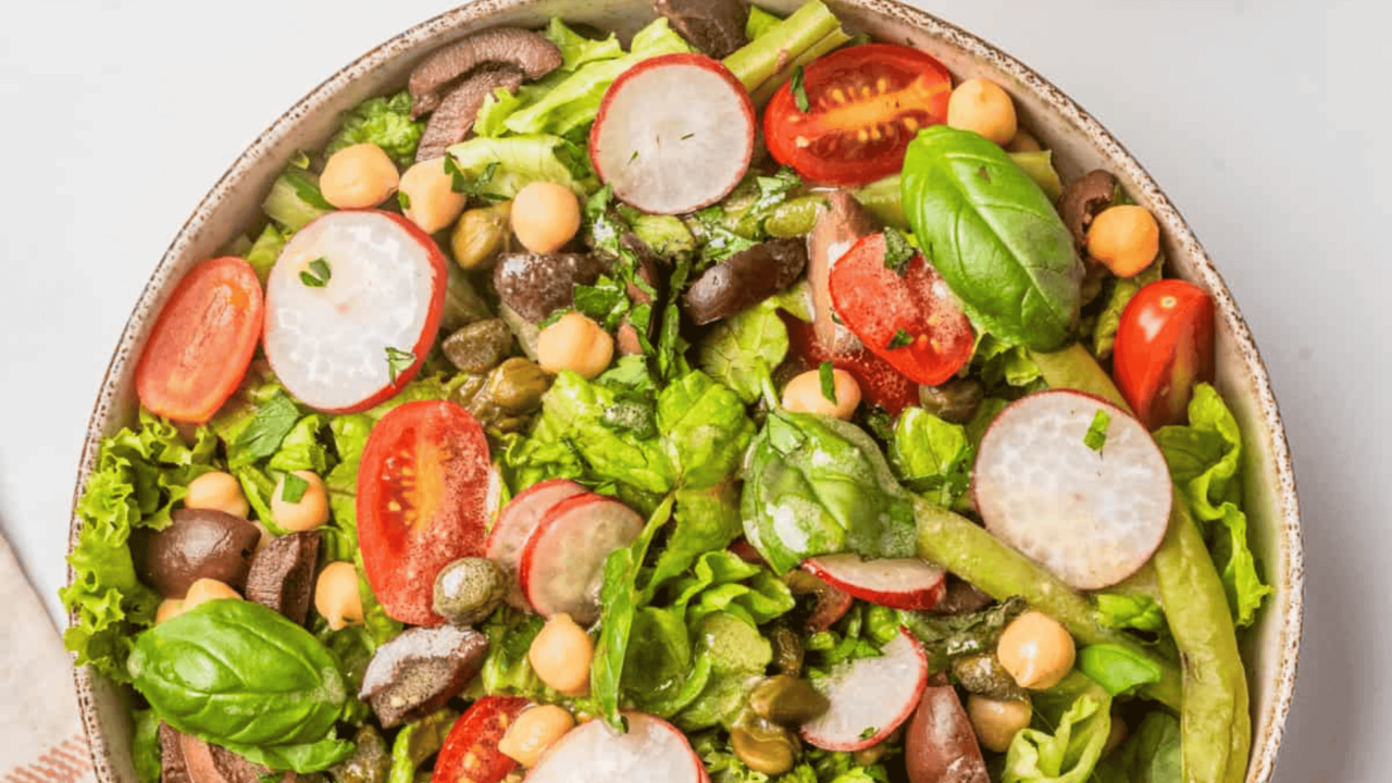 An image of vegan nicoise salad served on a big bowl.