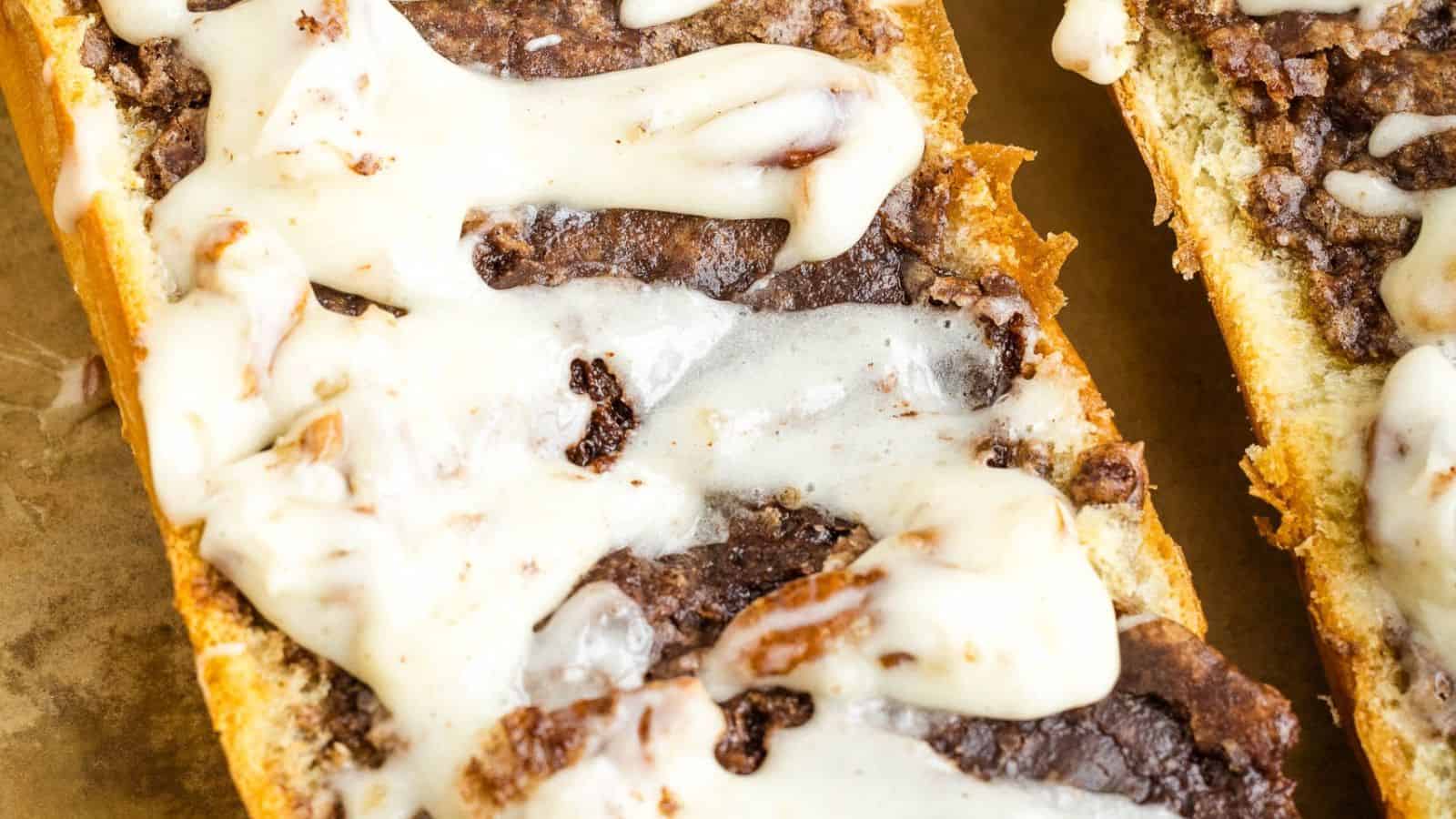 Close-up of a melted cheese and beef topping on sliced bread.