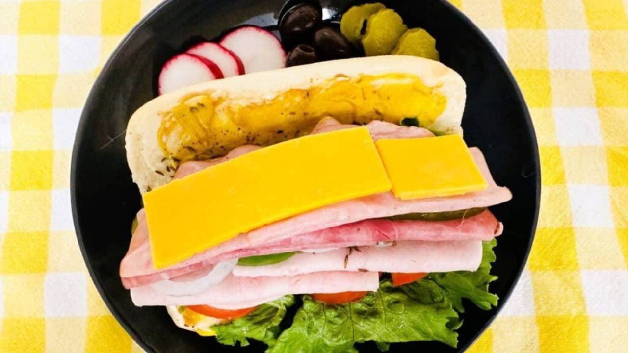 Side view of a hero sandwich with meats, cheese, and veggies.