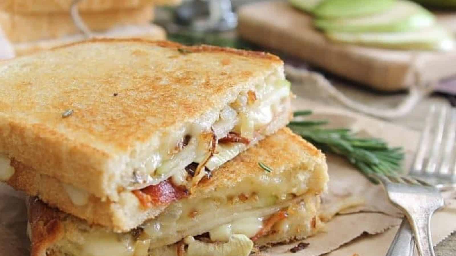 Pear bacon and brie grilled cheese on a plate with a knife.