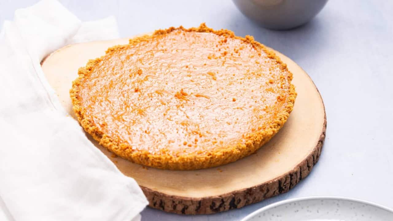 Whole Pumpkin Pie with Condensed Milk on a wooden board.