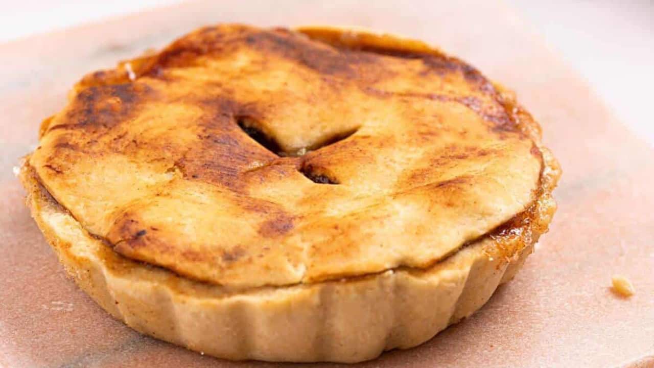Mini apple pie on cutting board.