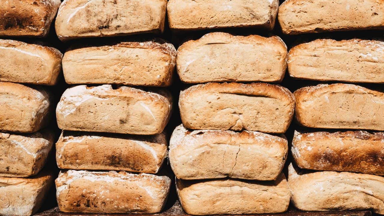 Stacks of rustic, crusty bread loaves arranged in rows.