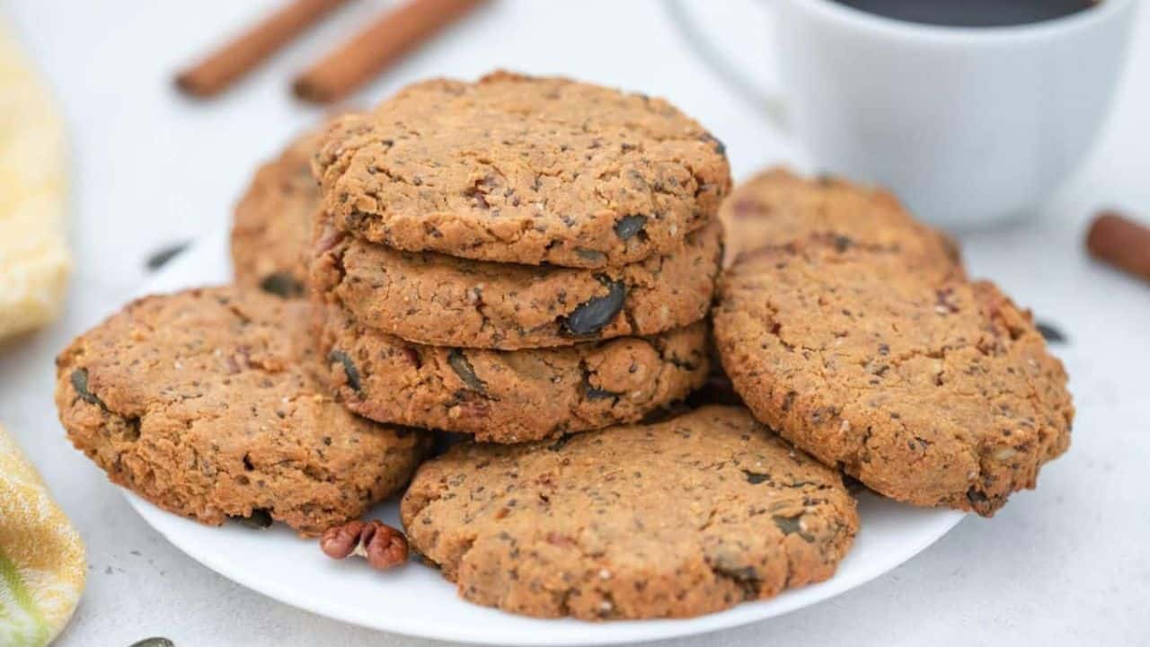 Seed and nut butter cookies on plate served with coffee.