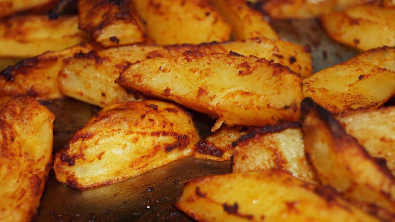 Close-up of seasoned and roasted potato wedges with a golden brown crust.