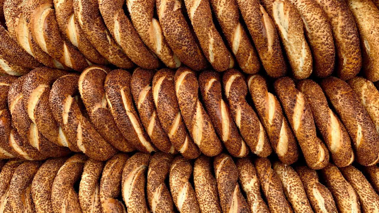 Stacks of circular sesame-covered bread rings arranged closely together.