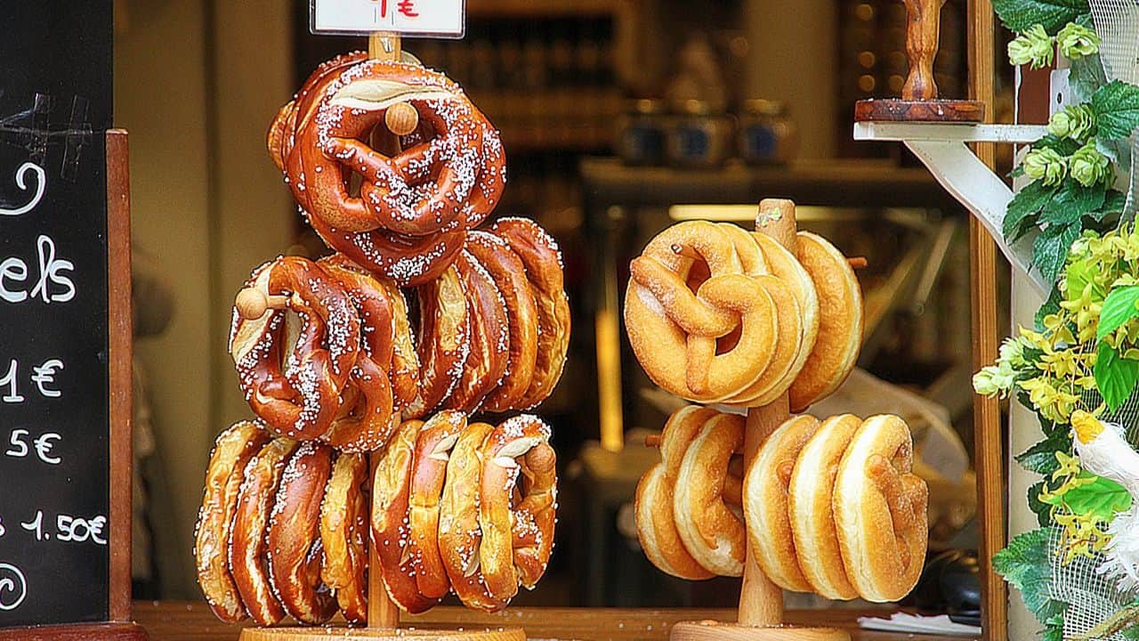 Display of freshly baked pretzels arranged on wooden stands in a bakery.