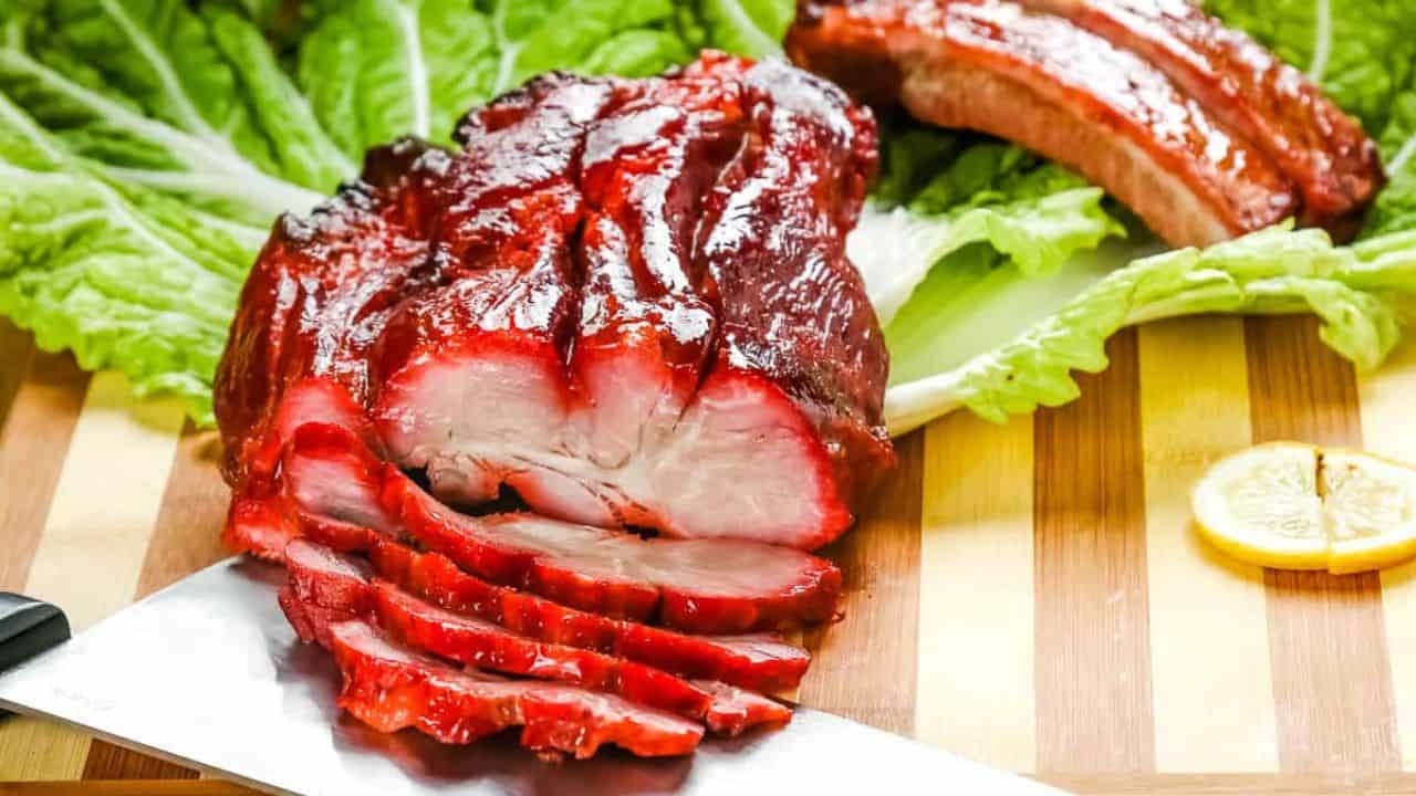 Sliced char siu pork with lettuce leaves.