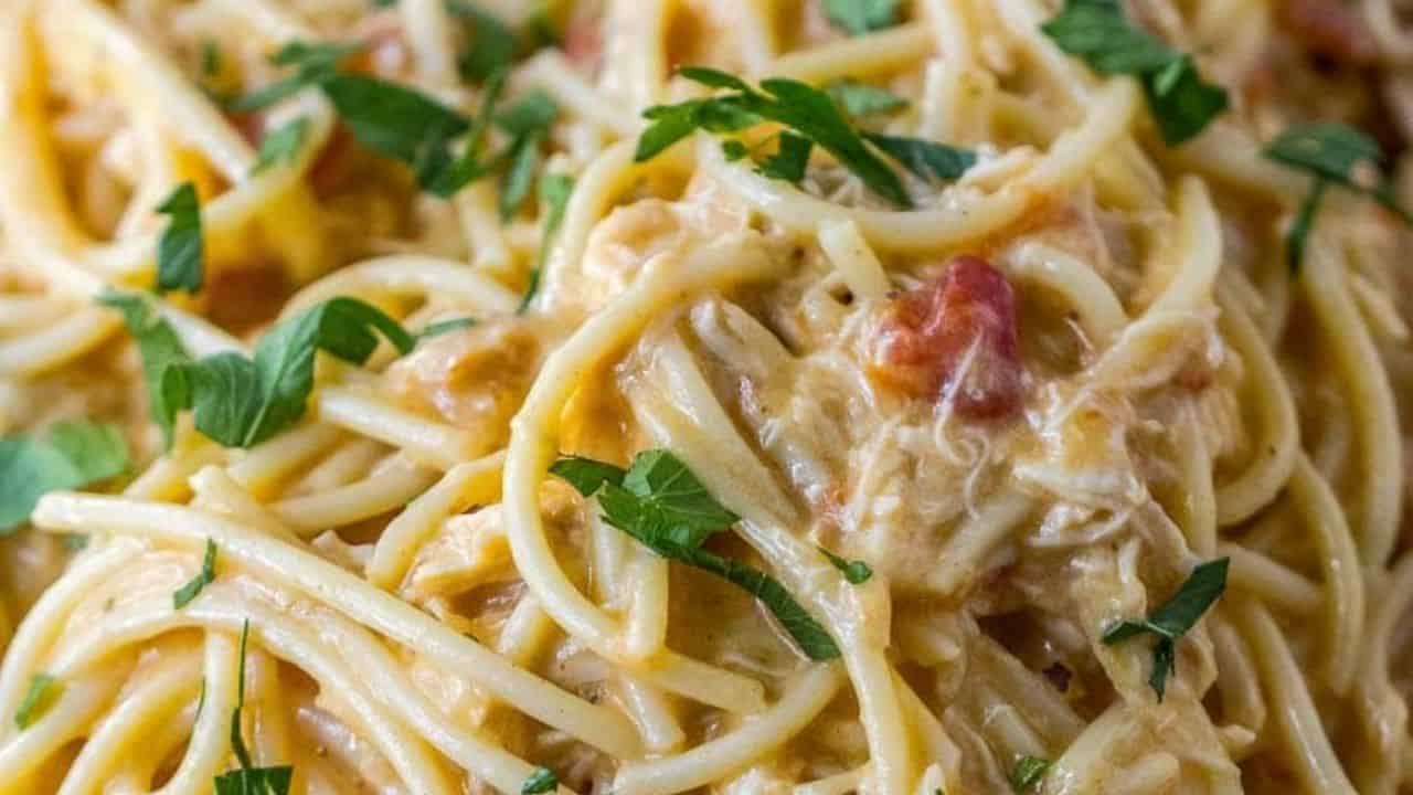 Close-up of spaghetti with creamy sauce, garnished with chopped parsley.