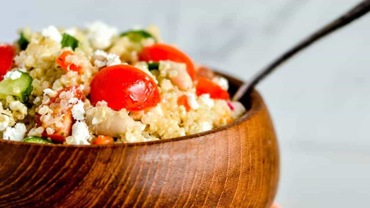 Quinoa salad in a brown bowl, garnished with pita bread.
