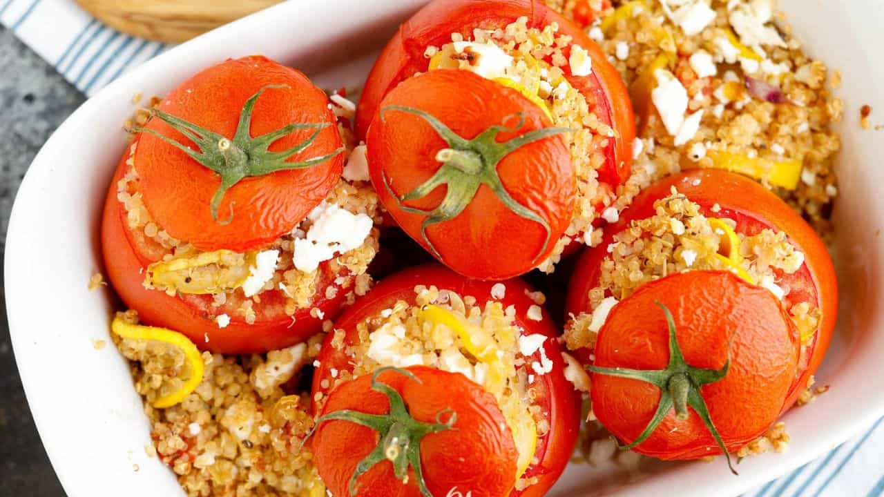 Flatlay of stuffed tomatoes with 'lids' on.