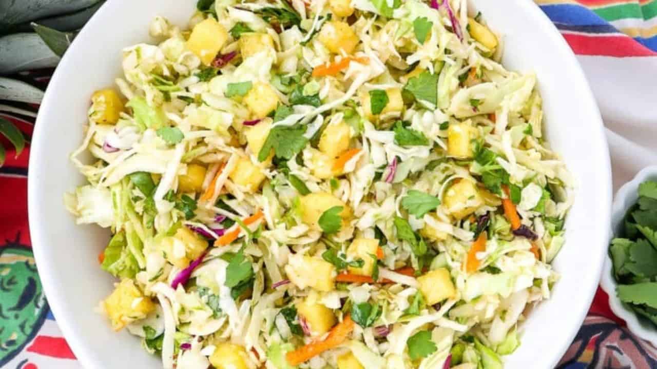 A bowl of Mexican cabbage slaw with shredded cabbage and colorful veggies.