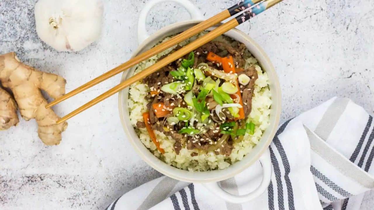 A top-down shot of Korean Beef Bowl with chopsticks and garlic.