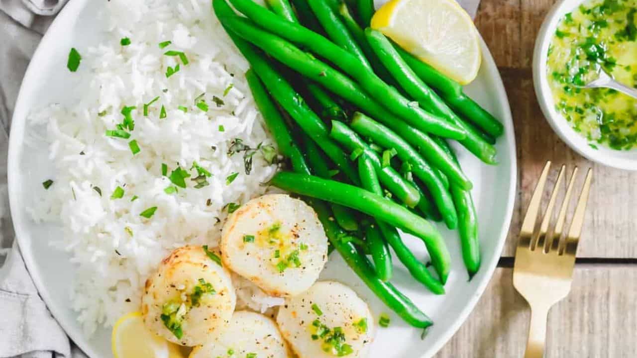 Air fryer scallops with green beans and rice on a plate.