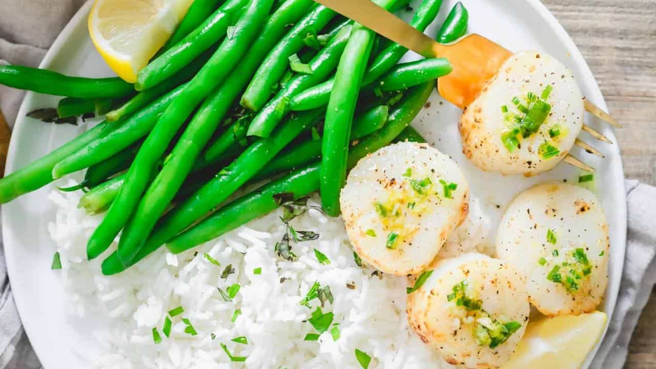 Air fryer scallops with green beans and rice on a plate.