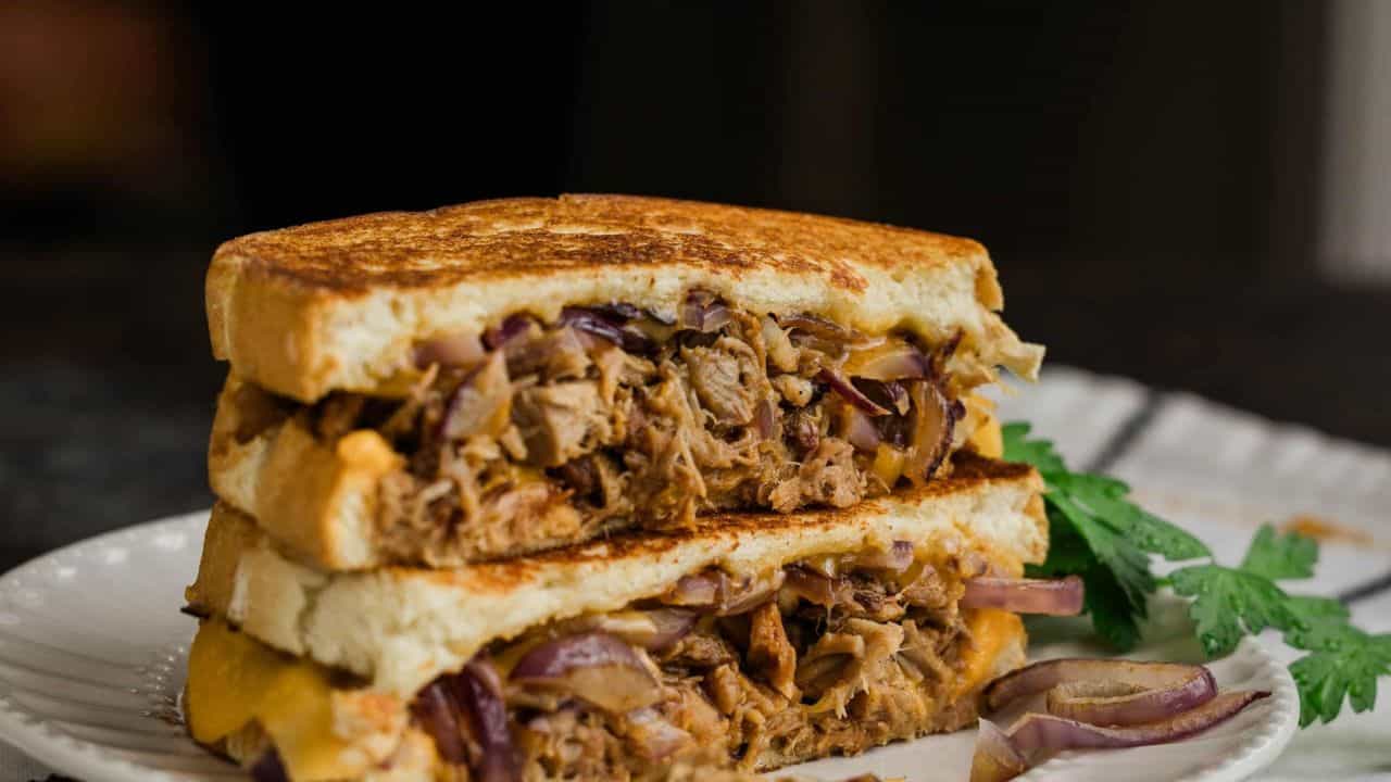 A stack of pulled pork grilled cheese on a plate.