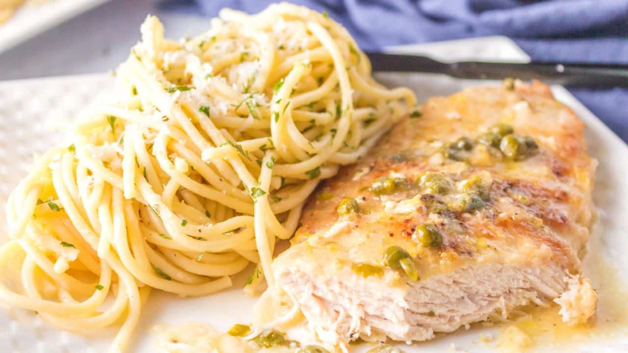 Chicken breast cut with pasta in the background.