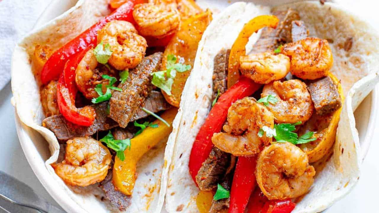 Shrimp and steak fajitas with peppers and onions.