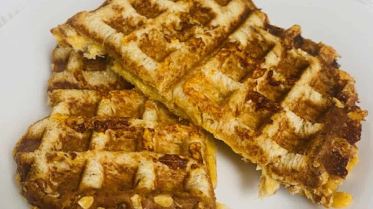 Waffle grilled cheese on a white plate with flowers.