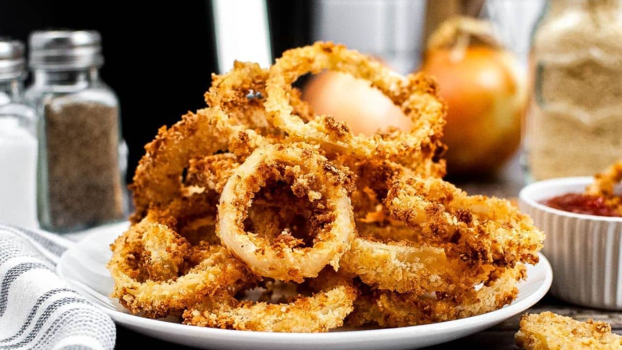 Pile of onion rings on a white plate.
