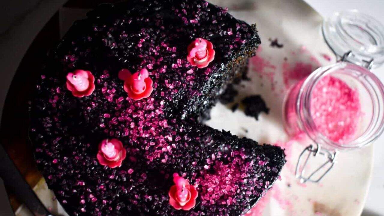 A Black Velvet cake with pink sprinkles on a plate.