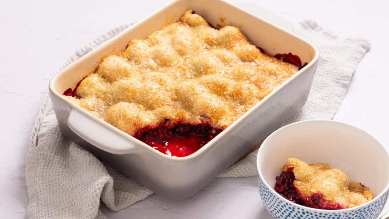 An image blackberry cobbler with pie crust in a baking dish.