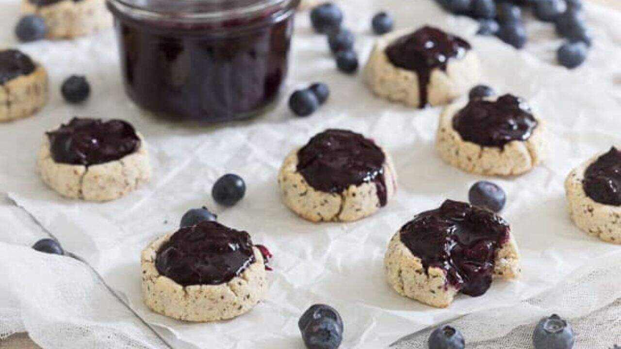 Blueberry thumbprint cookie on parchment paper.