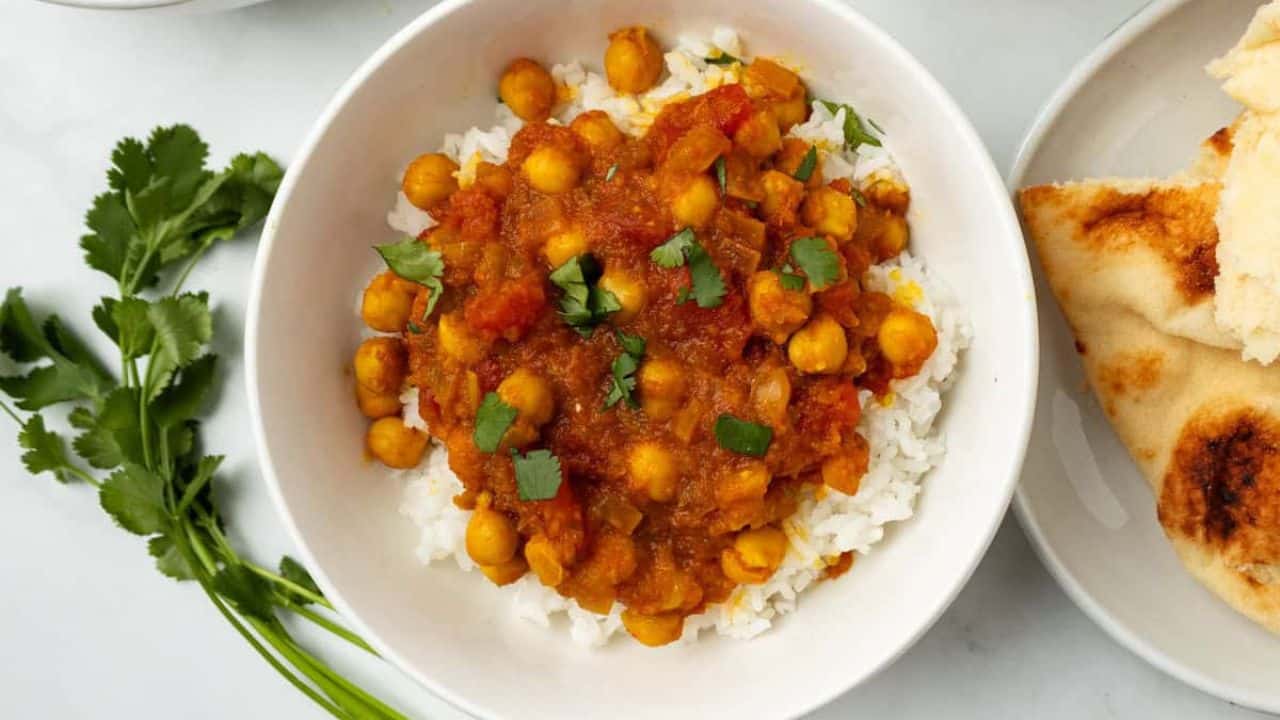 Top view image of chana masala served in a white bowl.