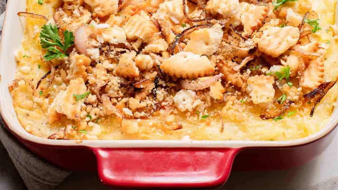 Masshed potato casserole in a baking dish with a cracker crumb topping.