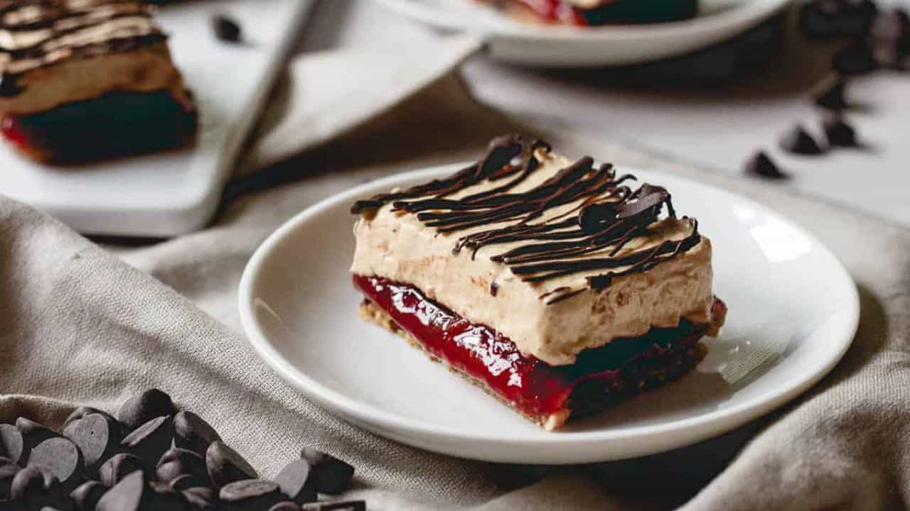 Chocolate peanut butter and jelly frozen yogurt bars on a plate with a spoon.