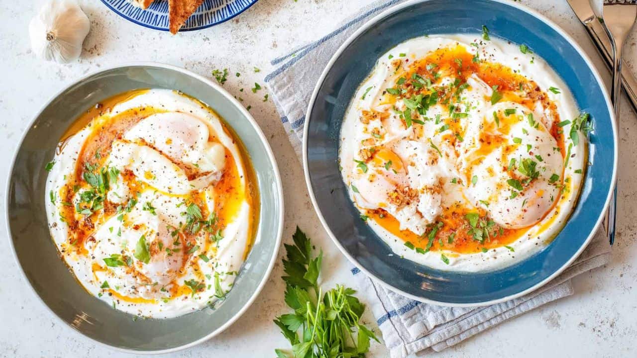 An overhead image of Cilbir, Turkish eggs, on a serving plate.
