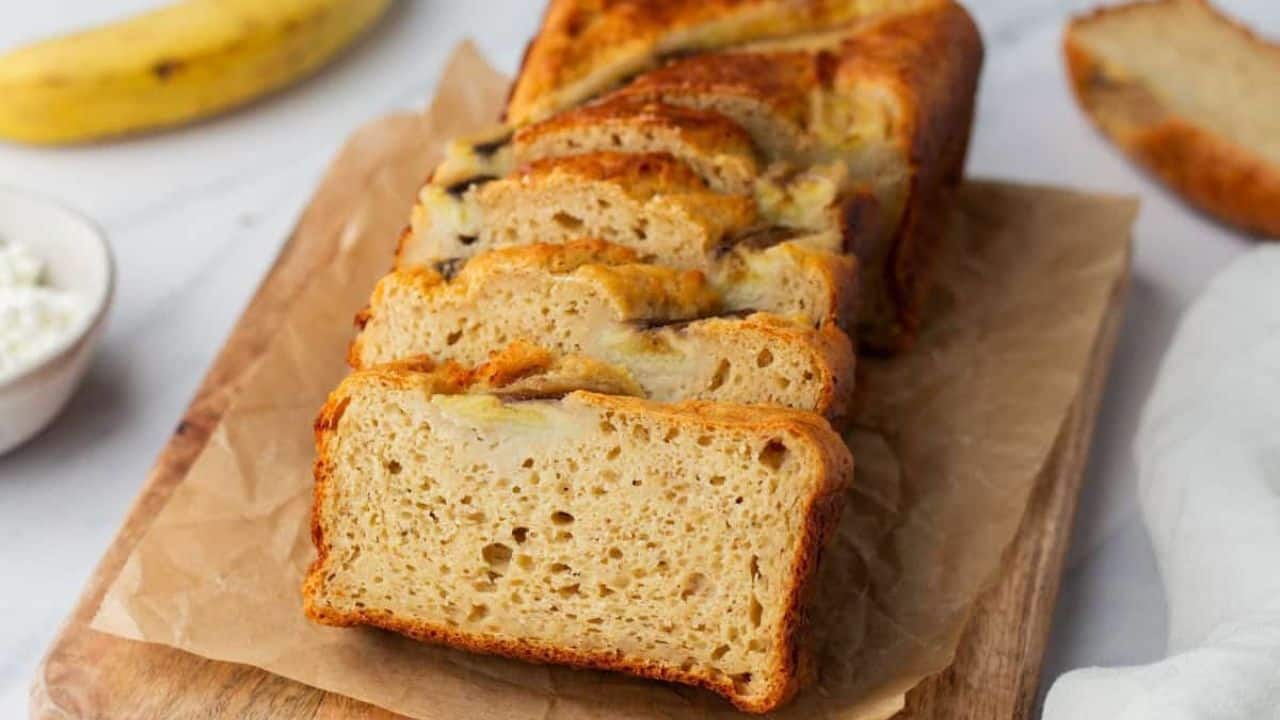 A close up image of sliced banana bread on a serving board.