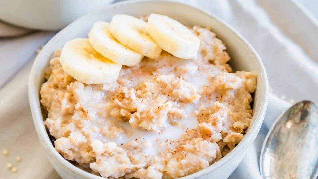 Creamy millet porridge in a small bowl with banana slices.