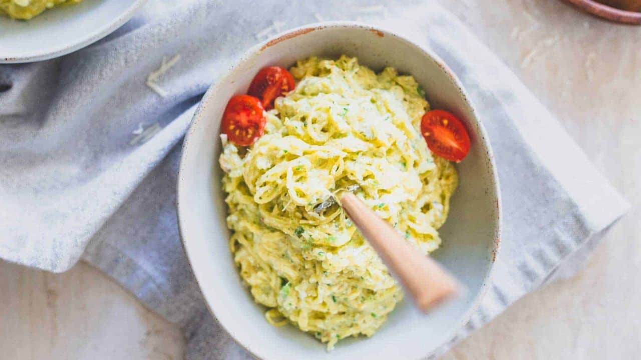 Pesto spaghetti squash noodles in a bowl with cherry tomatoes.