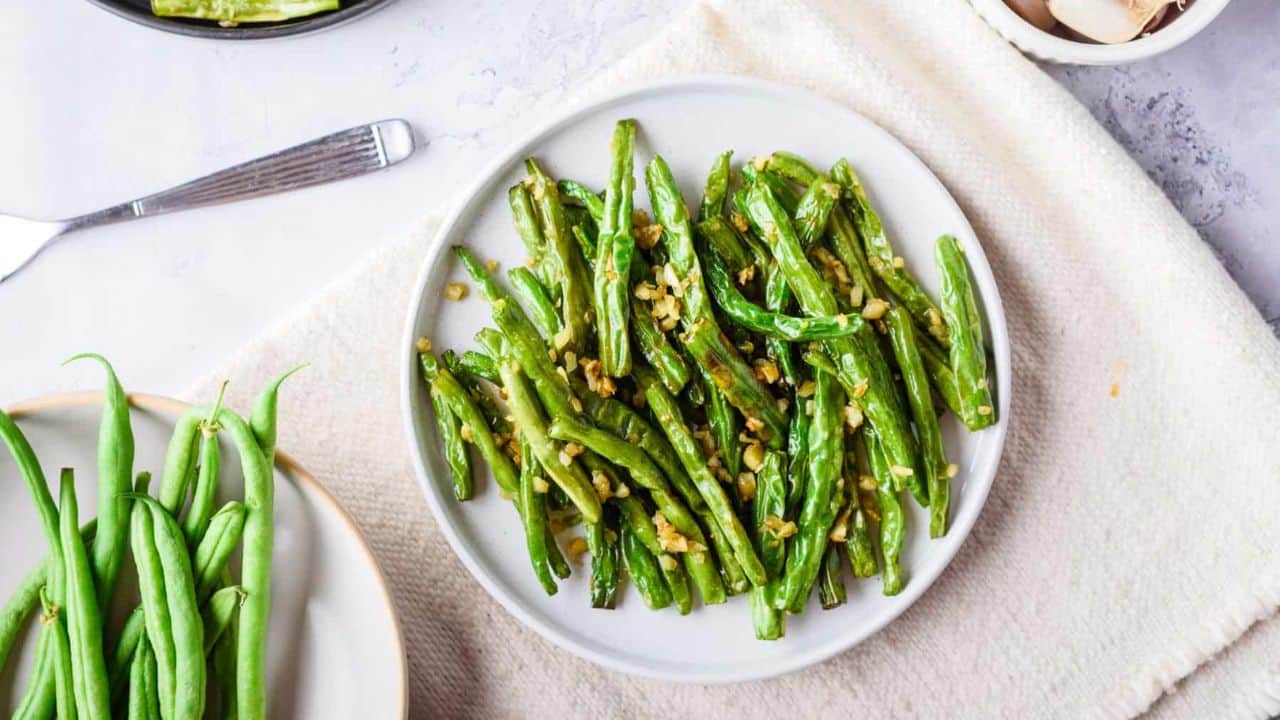 Overhead view of green beans placed on a paper towel on a platter.