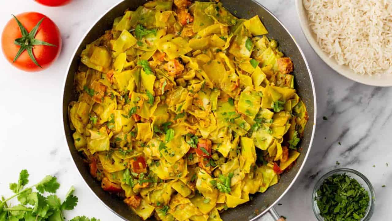 An overhead image of cooked cabbage curry in a round plate.