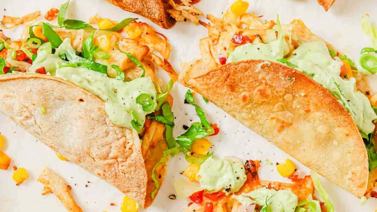 Fried chicken tacos on a red plate.