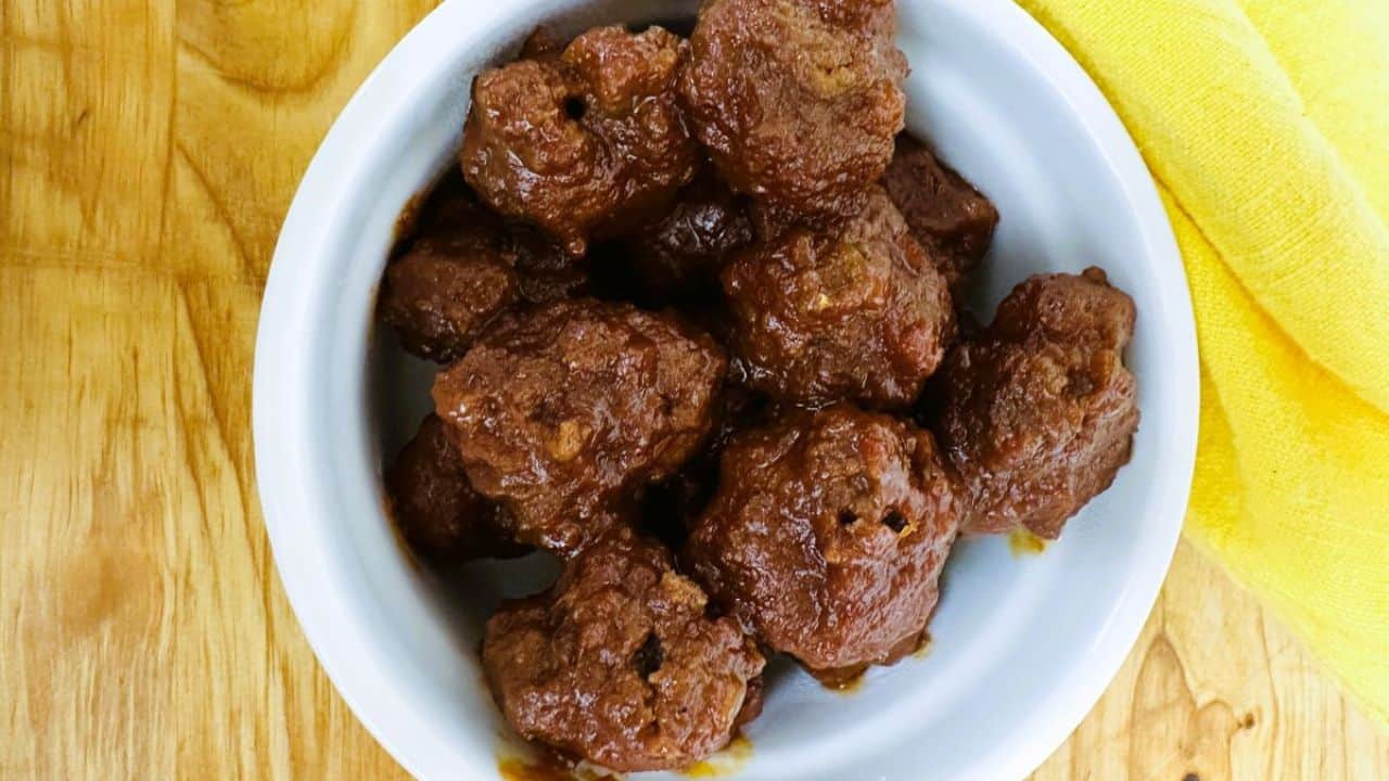 Meatballs in a white bowl on a wooden table.