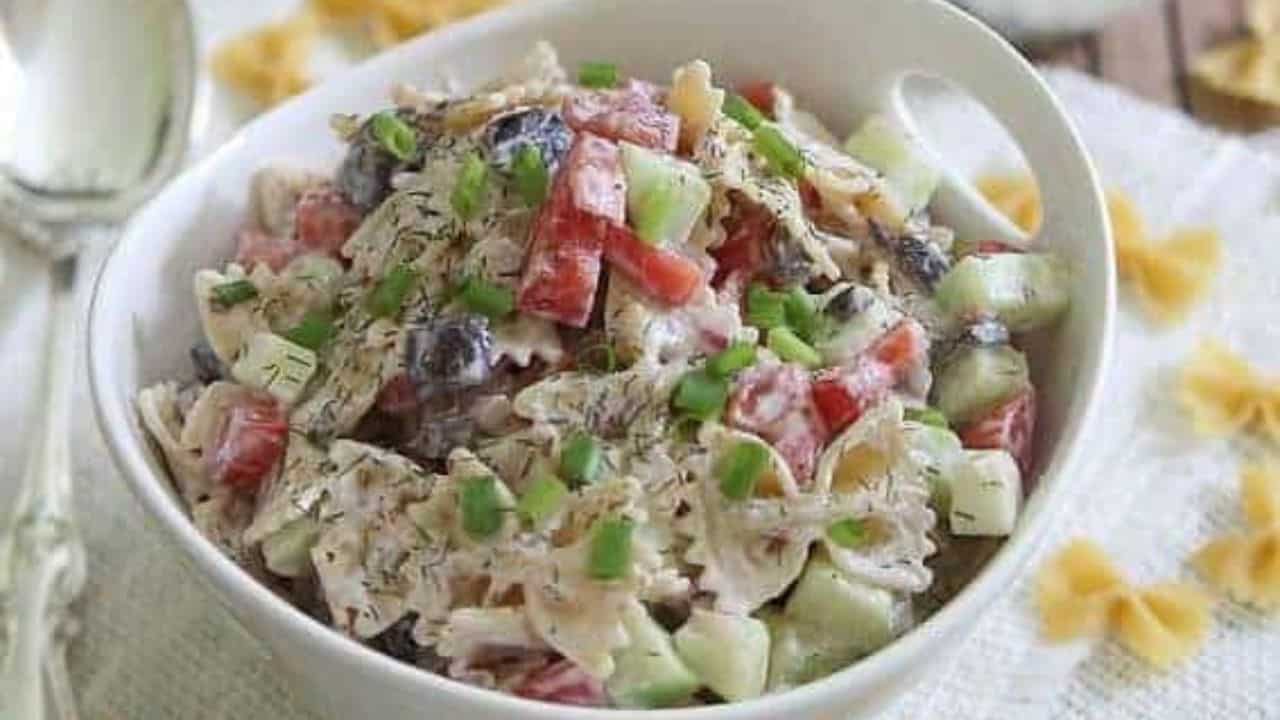 Greek pasta salad in a white bowl.