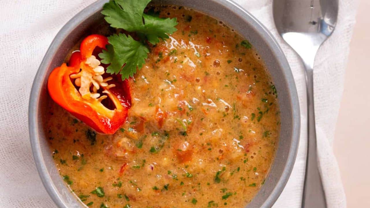 An image of habanero salsa garnished with peppers and cilantro.