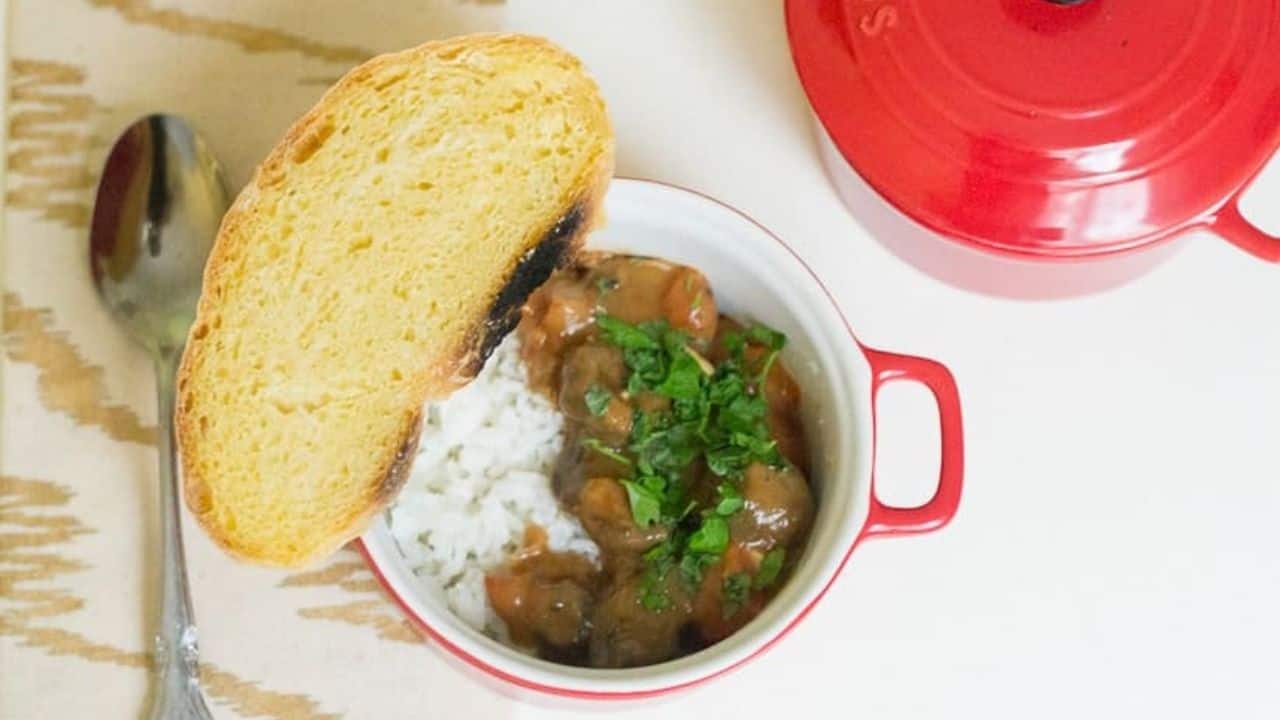 A red pot with rice and a spoon next to it, perfect for veggie mains.