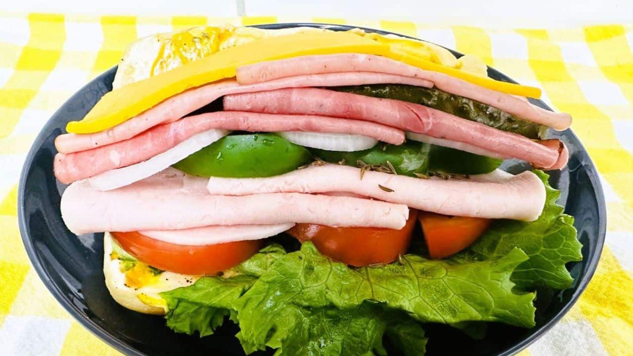 Side view of a hero sandwich with meats, cheese, and veggies.