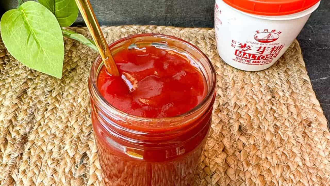 Sweet and tangy BBQ sauce made with only 2 simple ingredients in a jar with a golden spoon.