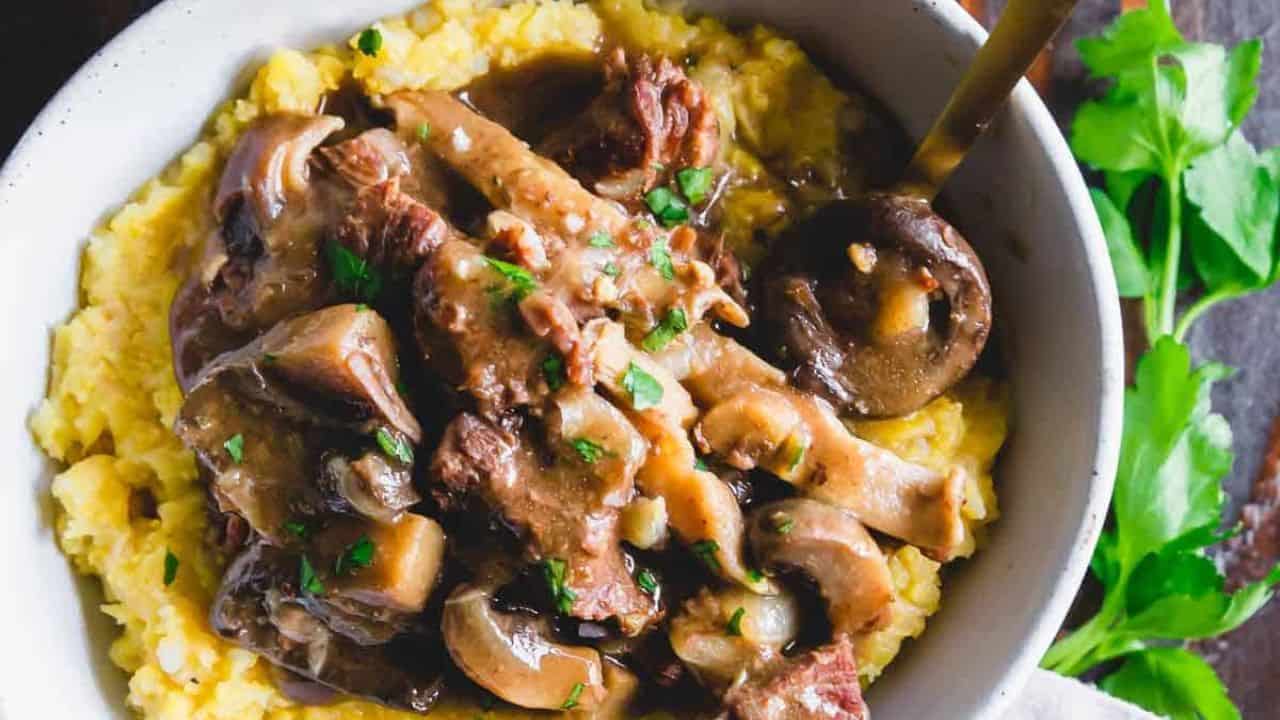 Instant Pot beef and mushroom stew served in a bowl over polenta.