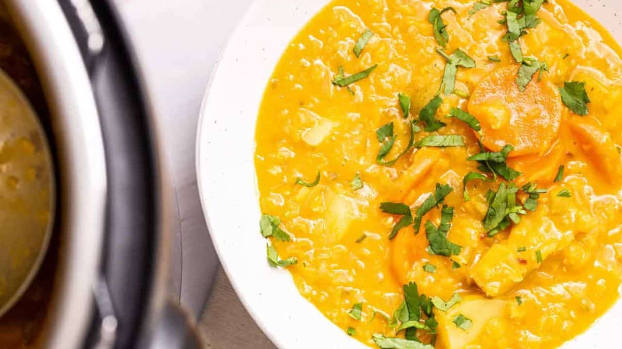 An overhead image of instant pot mulligatawny soup being scoop out from the pot.